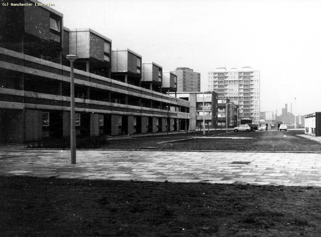 Black and white shot of Jackson Crescent flats with cars in distance.