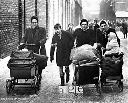 Women carrying bags of coal/coke in prams